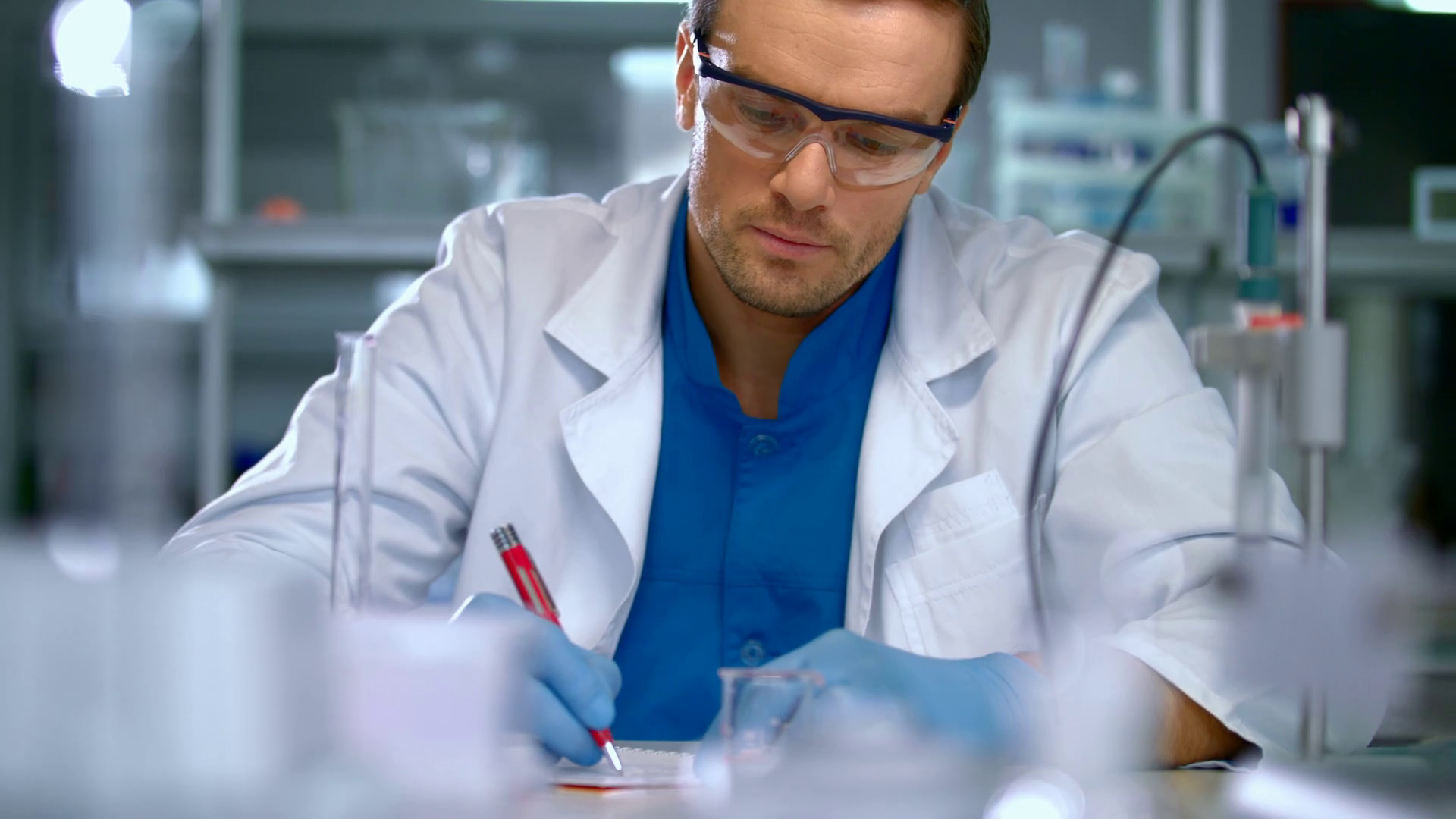 Scientist in lab doing medical research laboratory worker pour liquid from flask to measuring cup